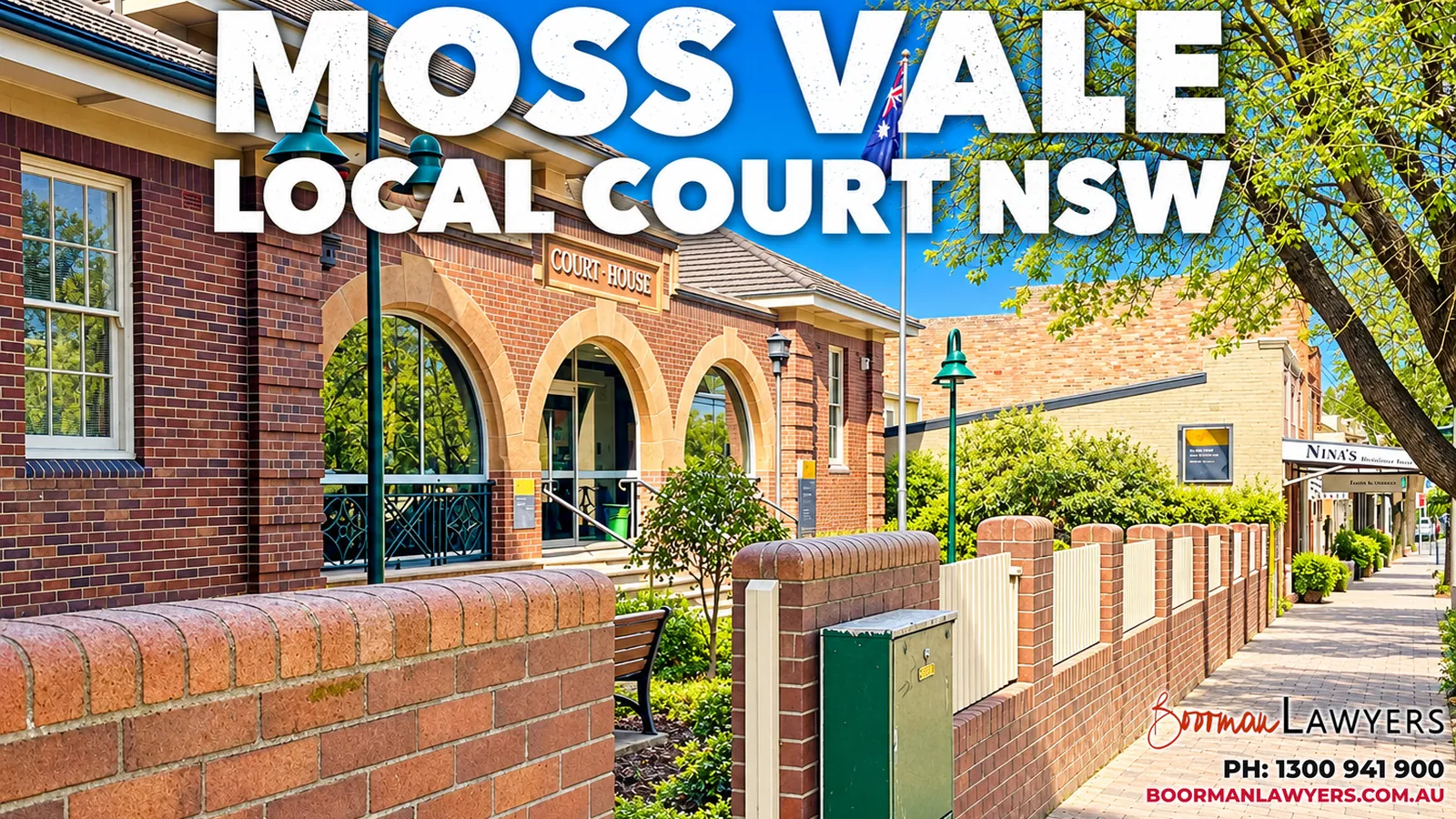 Moss Vale Court House, a red-brick building with arched windows and a low brick wall along a tree-lined Argyle Street footpath, with the Boorman Lawyers logo